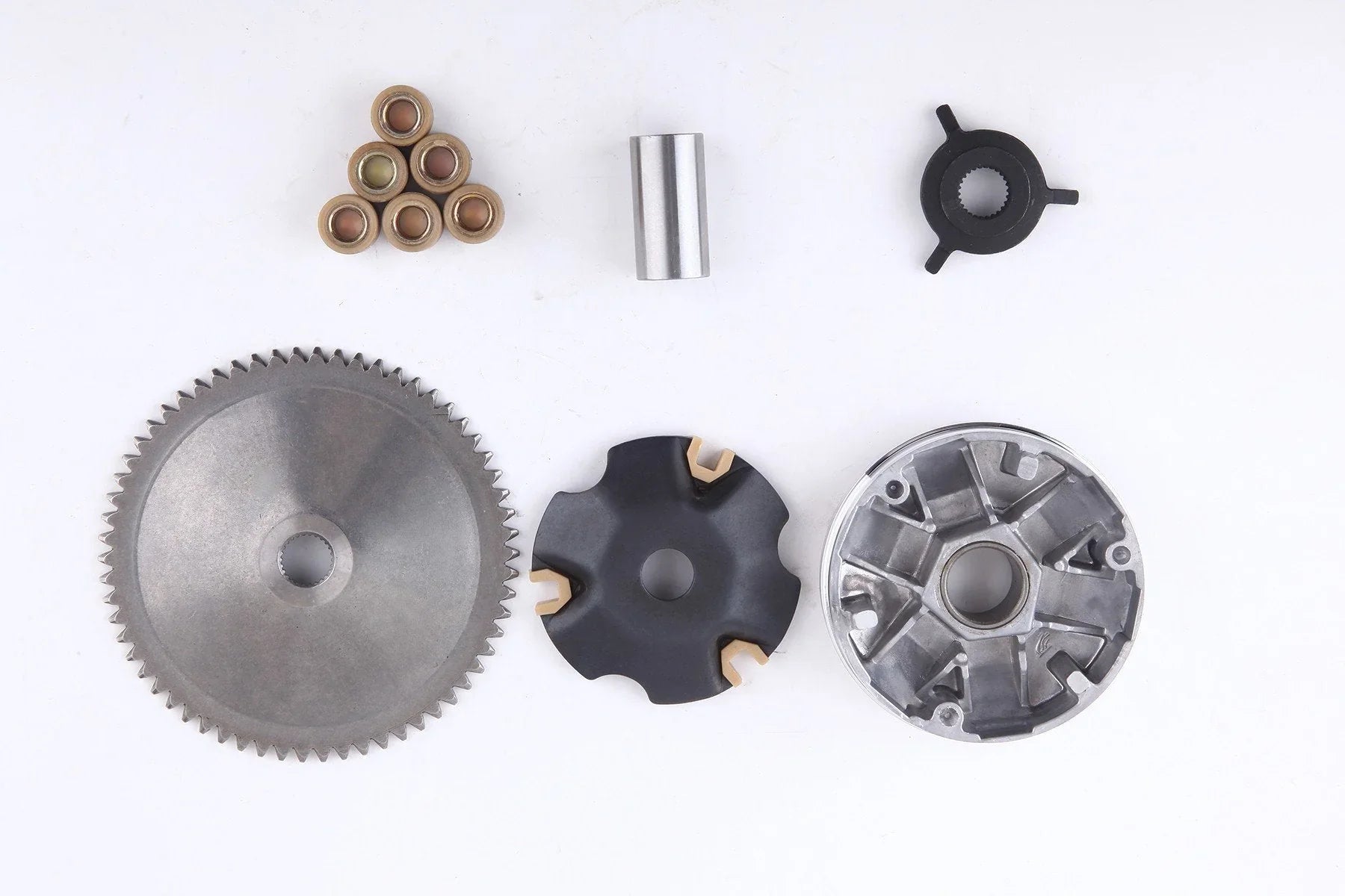 Assortment of metal mechanical parts including gear, rollers, black rotary component, and circular metal piece on white background