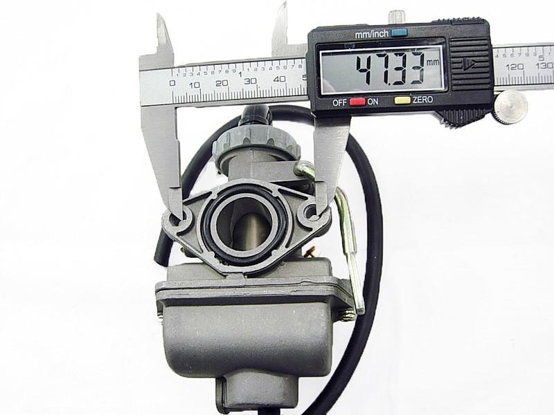 Digital caliper measuring 47.33mm diameter of carburetor intake pipe on a gray carburetor with black hose