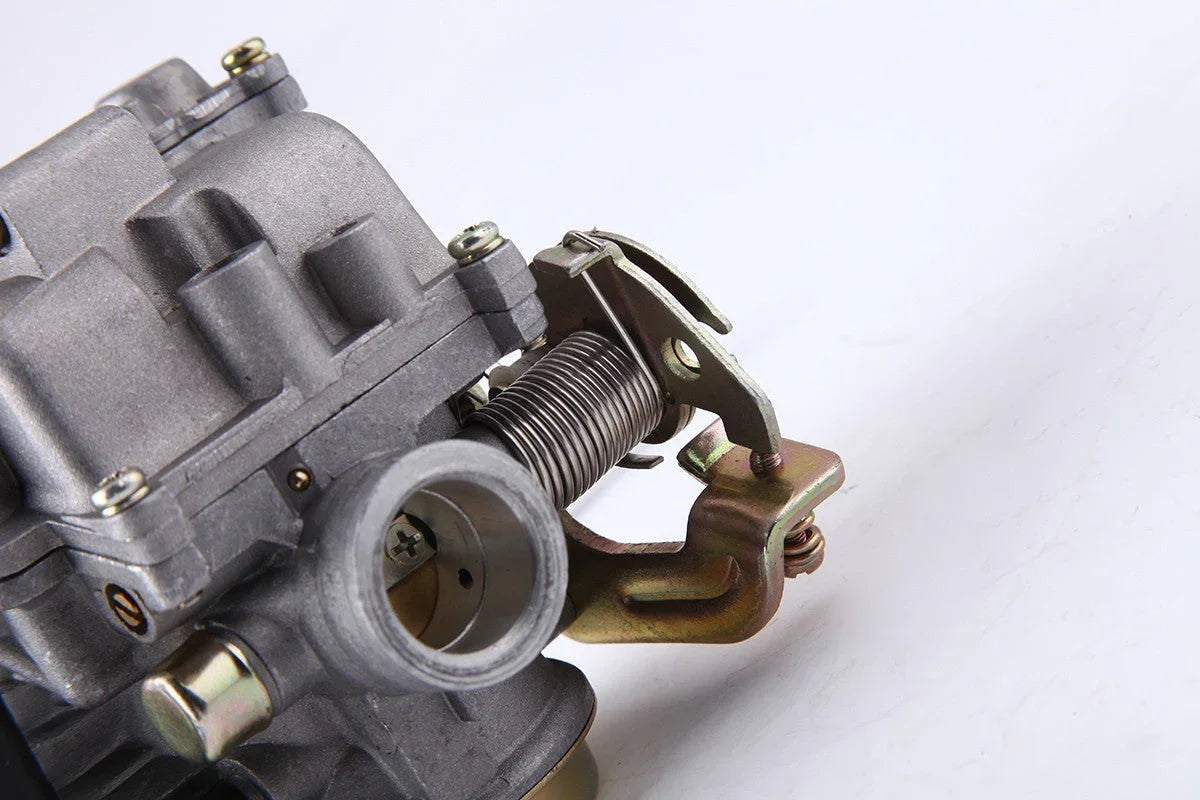 Close-up of a metallic carburetor throttle body with spring mechanism on white background