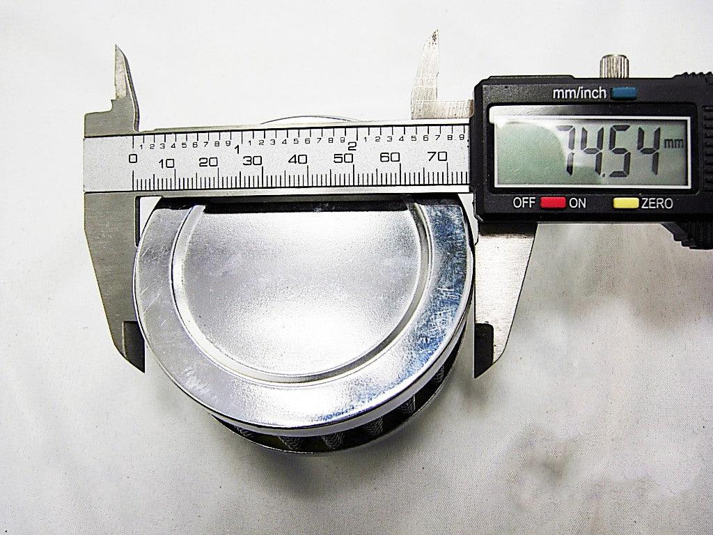Digital caliper measuring 74.54 mm diameter of a metallic round air filter