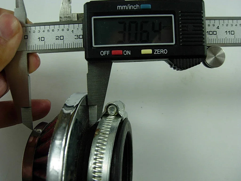 Digital caliper measuring 30.64 mm on a metal hose clamp attached to a red air filter