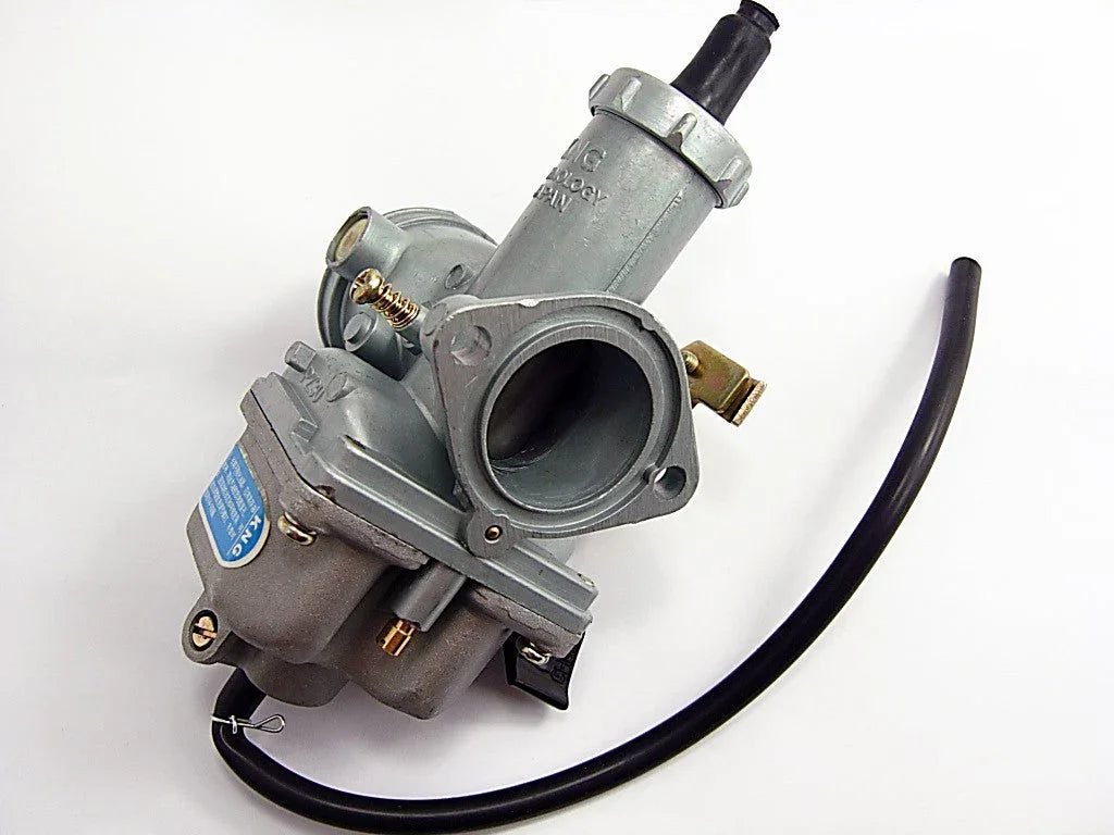 Close-up of a silver motorcycle carburetor with a black hose on a white background