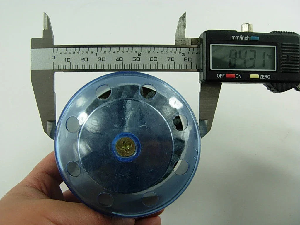 Digital caliper measuring diameter of transparent blue plastic object showing 84.31 mm