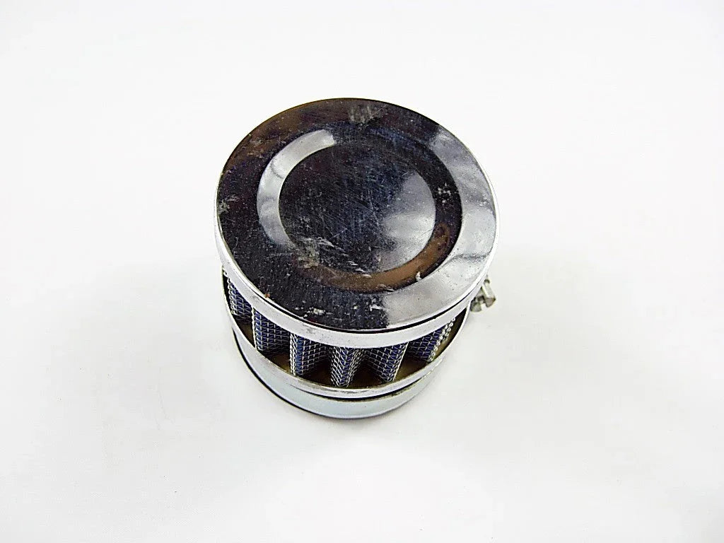 Small cylindrical metal air filter with mesh sides and reflective top on white background