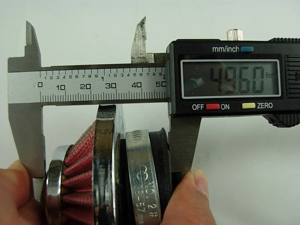 Digital caliper measuring 49.60 mm on a red fabric air filter with metal rim