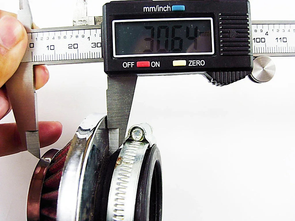 Digital caliper measuring 30.64 mm on a red conical air filter with metal and rubber parts