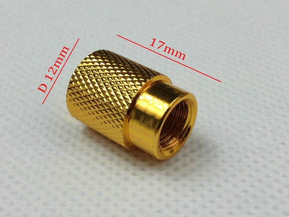 Gold knurled metal cap with inner threading, 17mm length and 12mm diameter on white textured surface