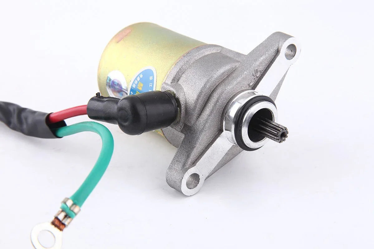 Close-up of a small electric motor with two wires and mounting bracket on white background