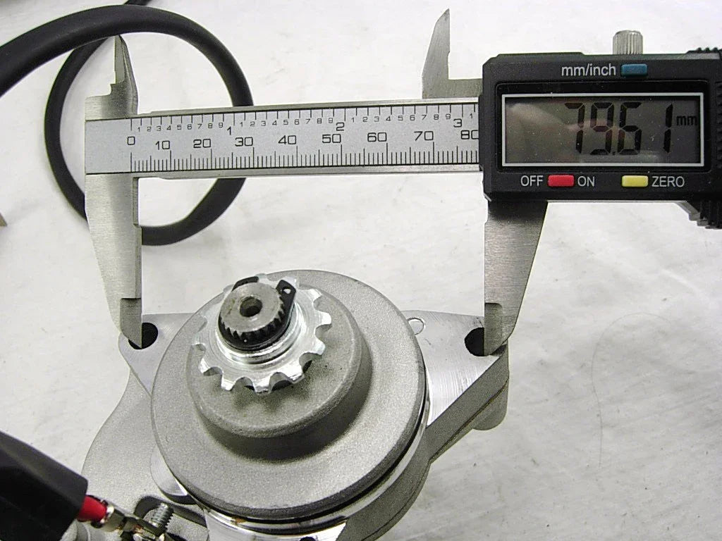 Digital caliper measuring 79.61 mm on a mechanical gear component with cable on white background