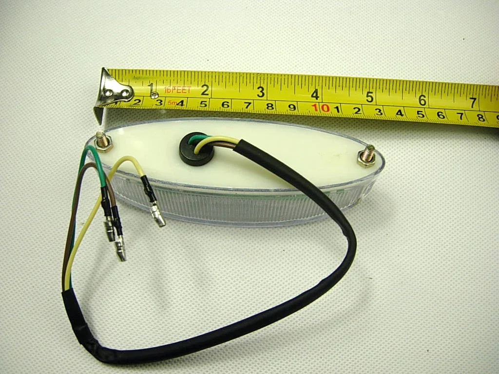 Oval clear lens boat trailer light with wiring and measuring tape showing 7 inches