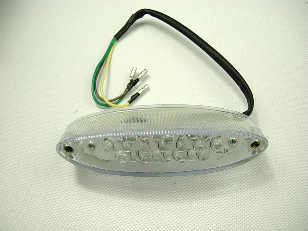 Clear oval LED motorcycle tail light with wiring harness and black cable on white background
