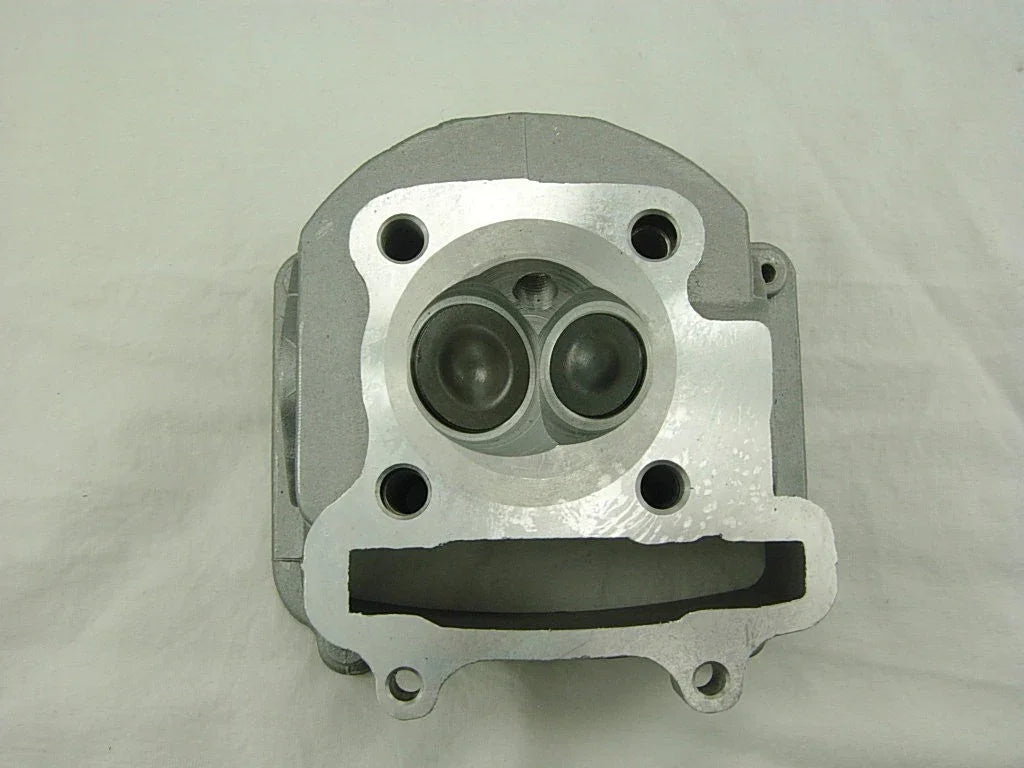 Close-up of a metallic engine cylinder head showing intake and exhaust valve openings