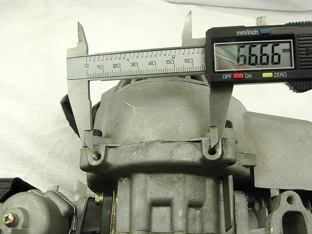 Digital caliper measuring 66.66mm on motorcycle engine part for ATV, dirt bike, or scooter