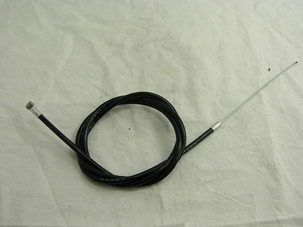 Black motorcycle throttle cable with metal ends, coiled on white fabric background