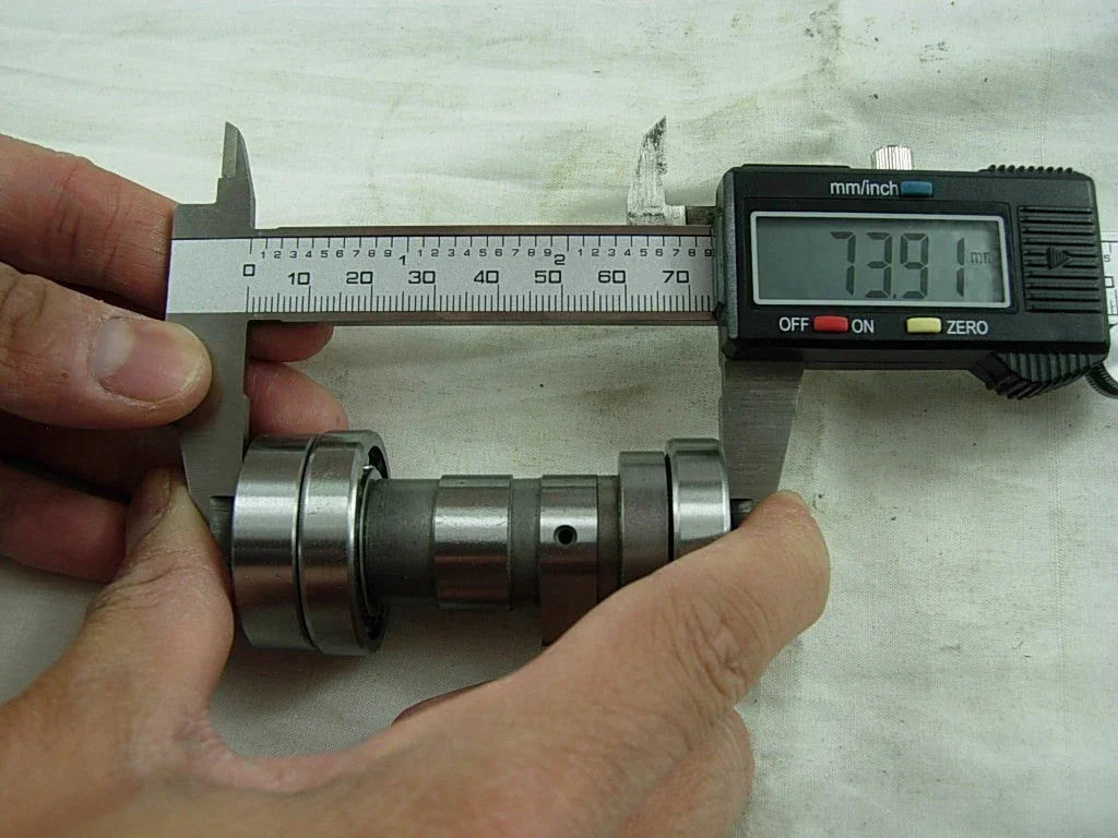 ChinesePartsUSA 110cc dirt bike camshaft showing metal shaft with gear and cam lobes for engine performance.