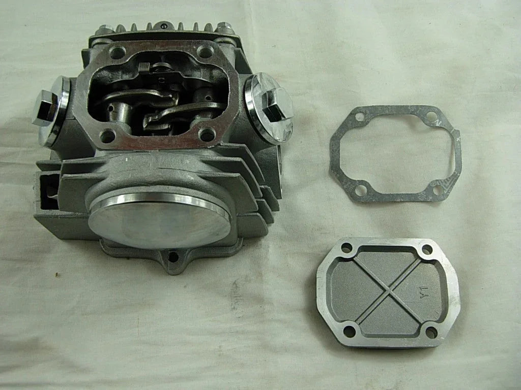 110cc engine cylinder head assembly for dirt bikes from ChinesePartsUSA, featuring metal components and valve openings.