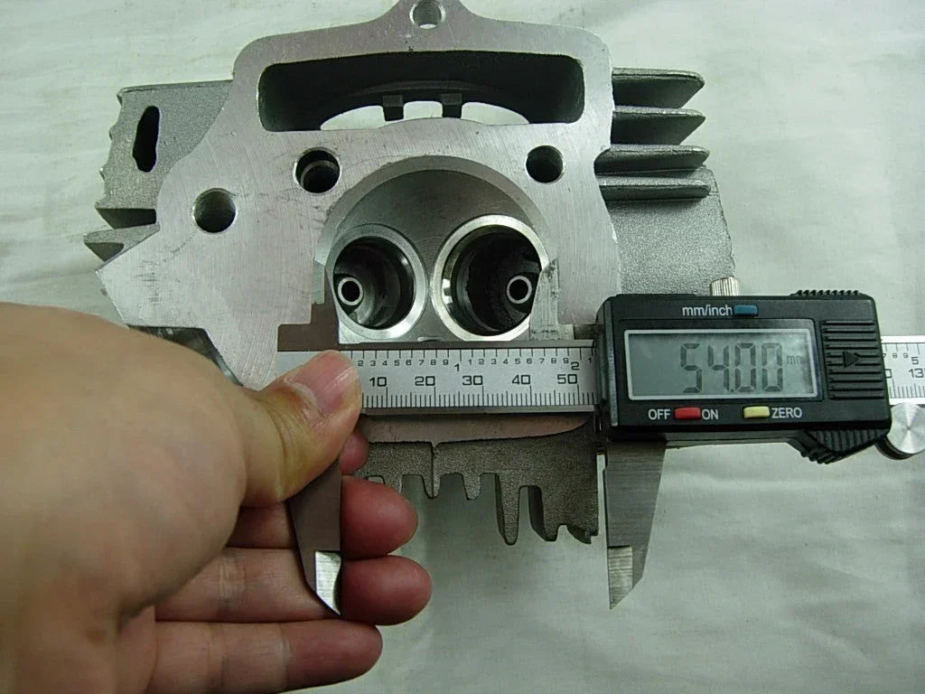 ChinesePartsUSA 125cc E22-style dirt bike engine cylinder head showing metal cooling fins and mounting points.