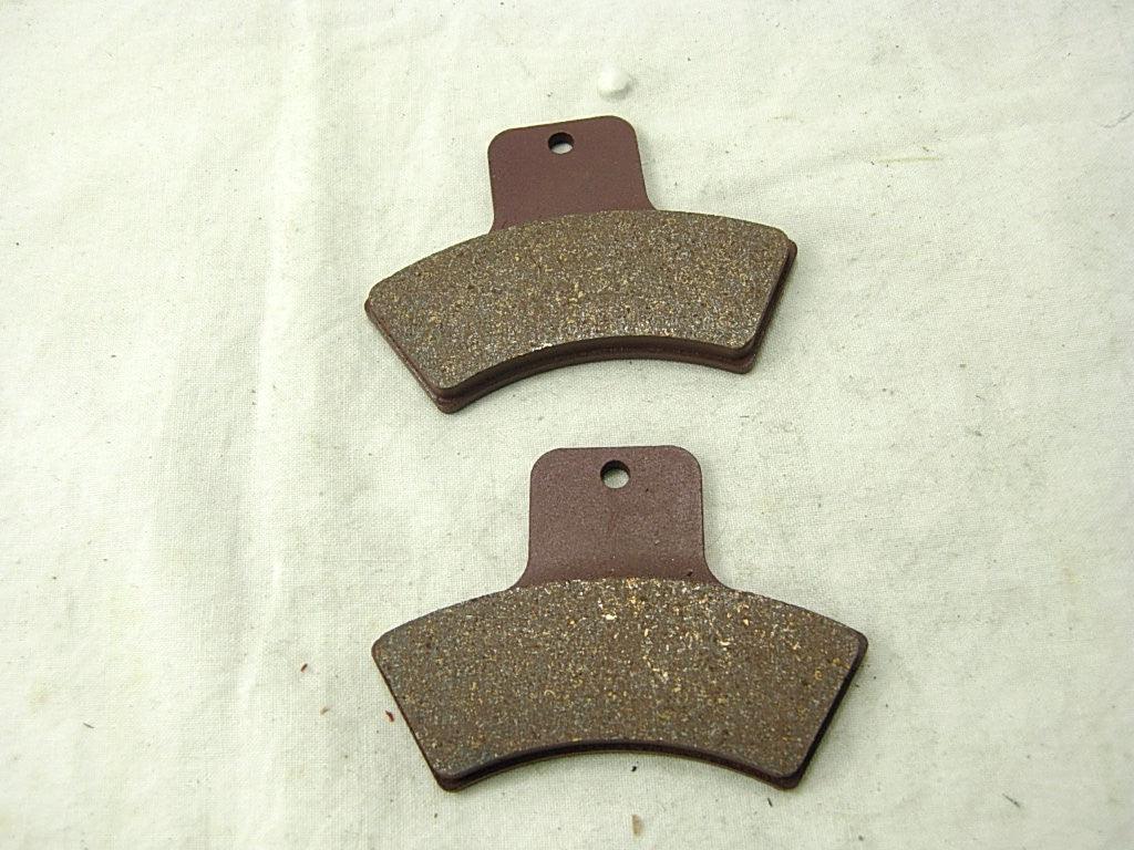 Set of ChinesePartsUSA dirt bike brake pads showing new brake pads with metal backing plates and friction material.