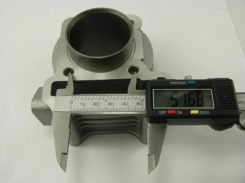 Digital caliper measuring 51.68 mm diameter on a silver metal engine cylinder part