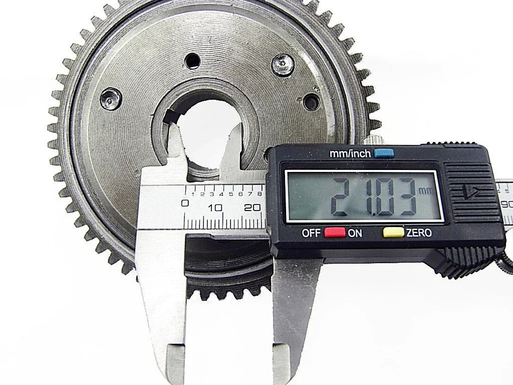 Digital caliper measuring the diameter of a metal gear showing 21.03 mm on display