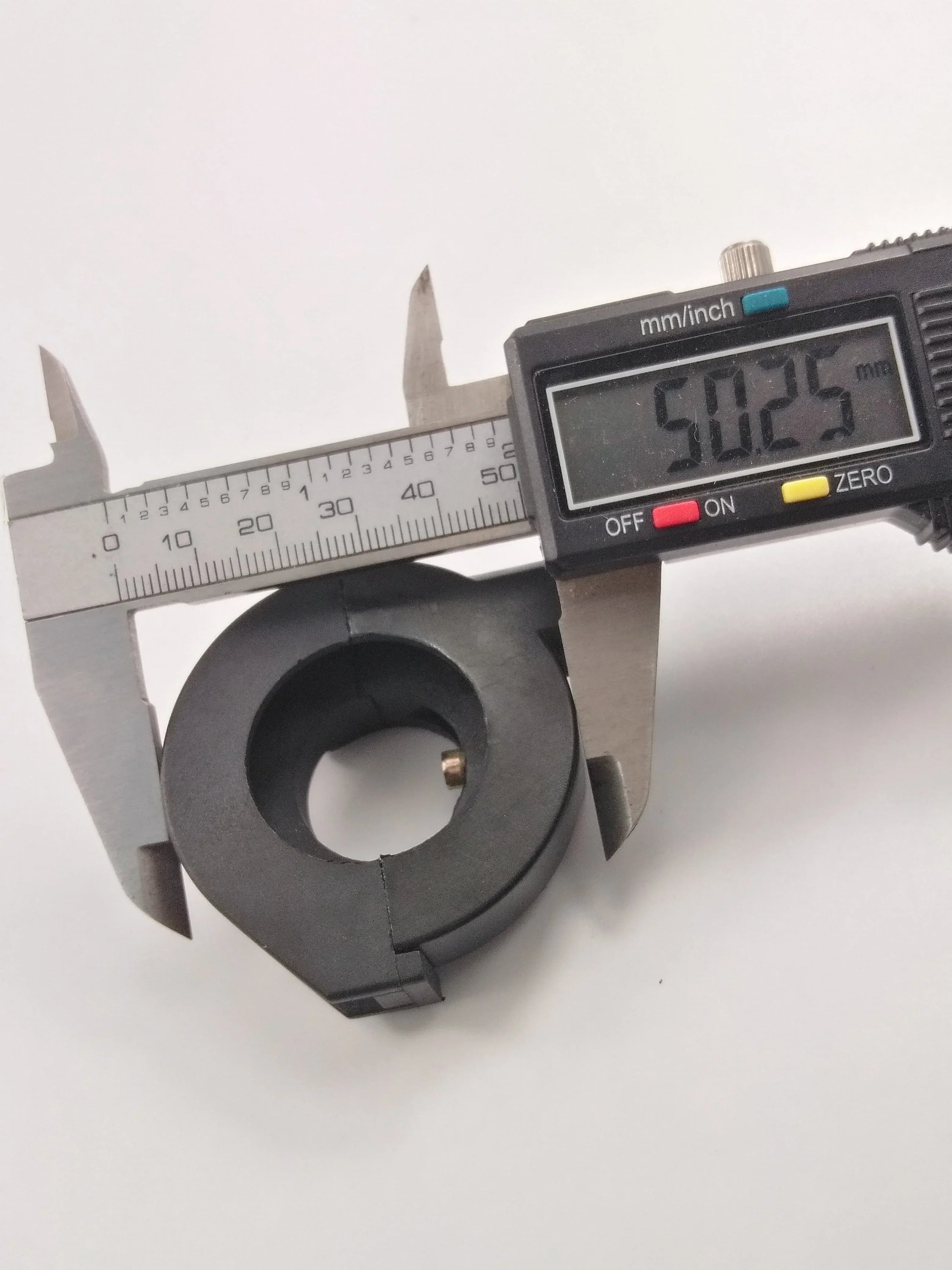 Black motorcycle or ATV part measured at 50.25mm with digital caliper, precision vehicle component