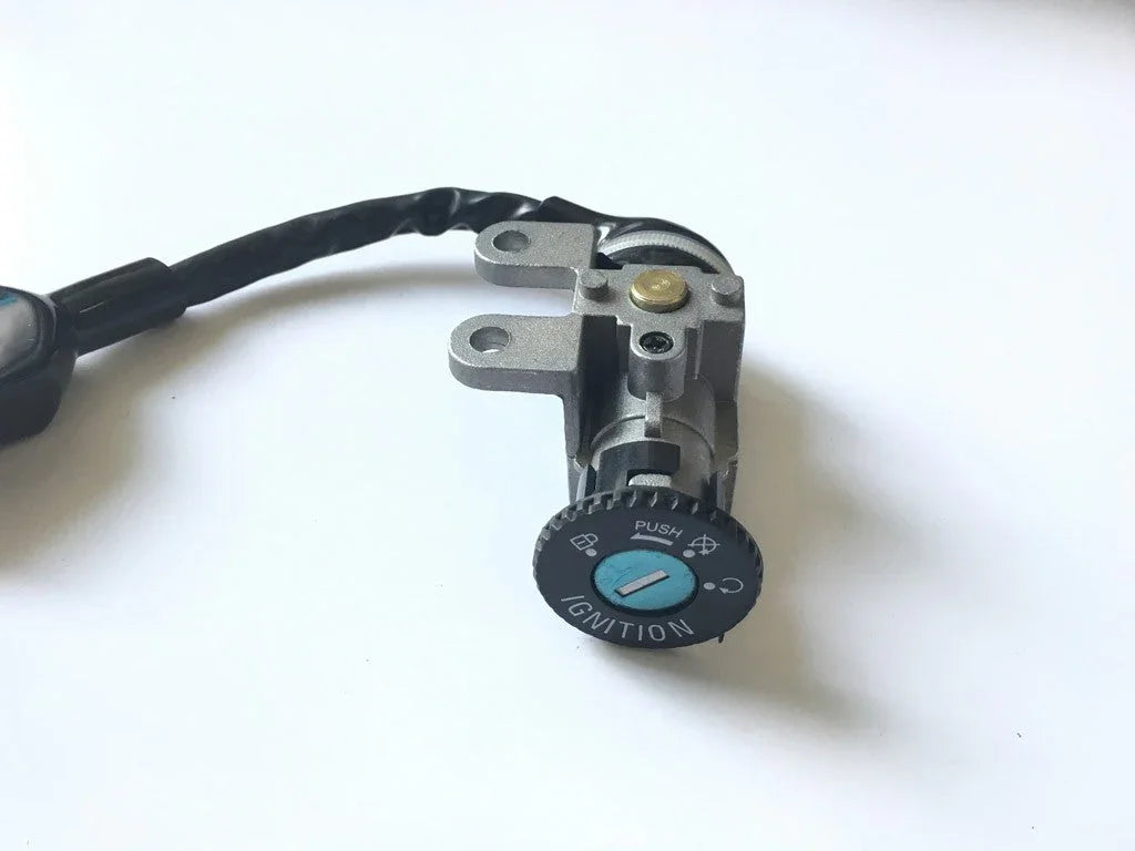 Universal motorcycle or scooter ignition switch with key slot and wiring harness on white background