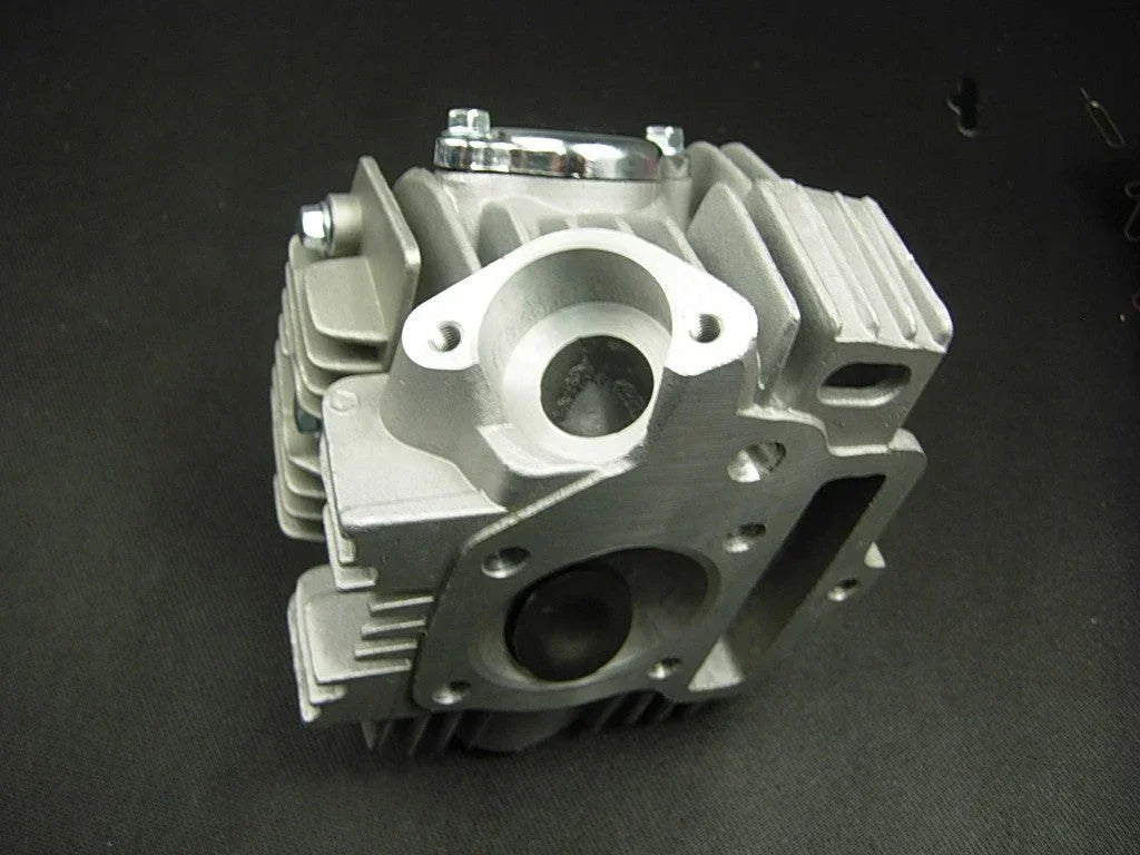 125cc E22 style dirt bike engine cylinder head assembly with cooling fins and valve openings, suitable for off-road motorcycle repairs
