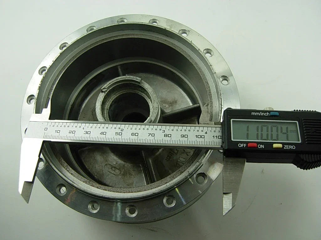 Front wheel hub for A100 engine motorcycle, black metal part with mounting holes, essential for wheel assembly.