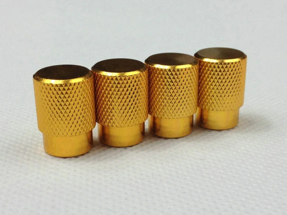 Set of four gold tire air valve stem caps with textured grip, for automotive wheels