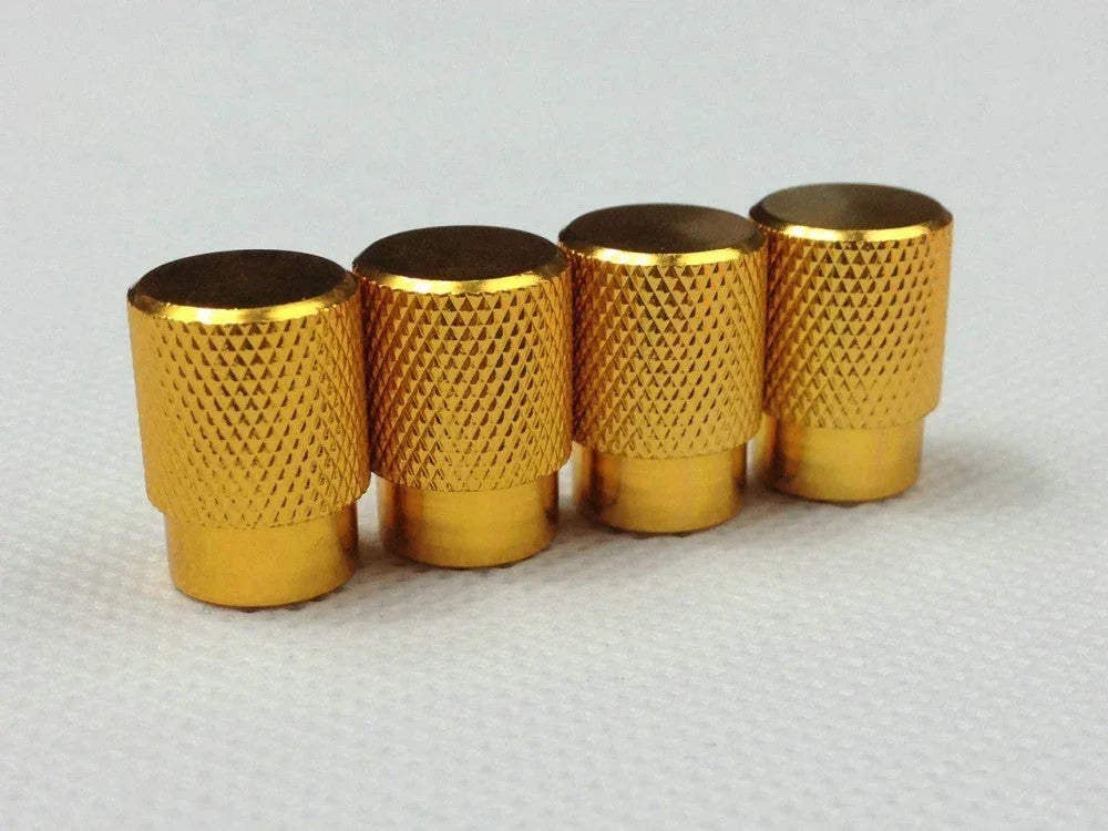 Set of four gold tire air valve stem caps with textured grip, for automotive wheels