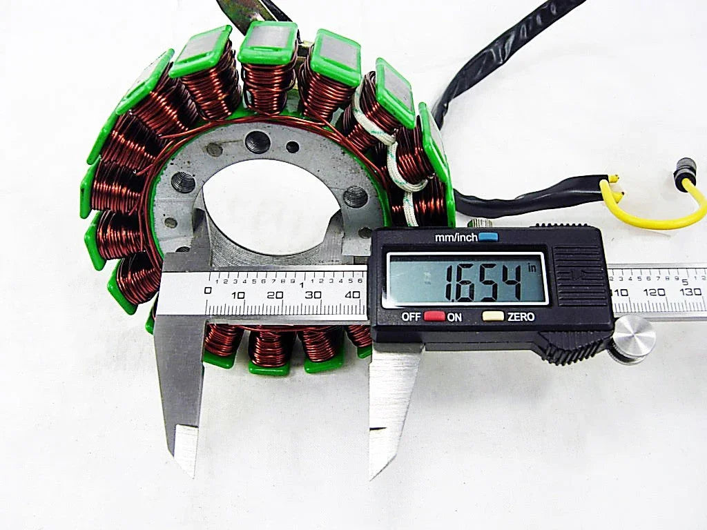 Digital caliper measuring diameter of copper coil stator with green insulation on white background