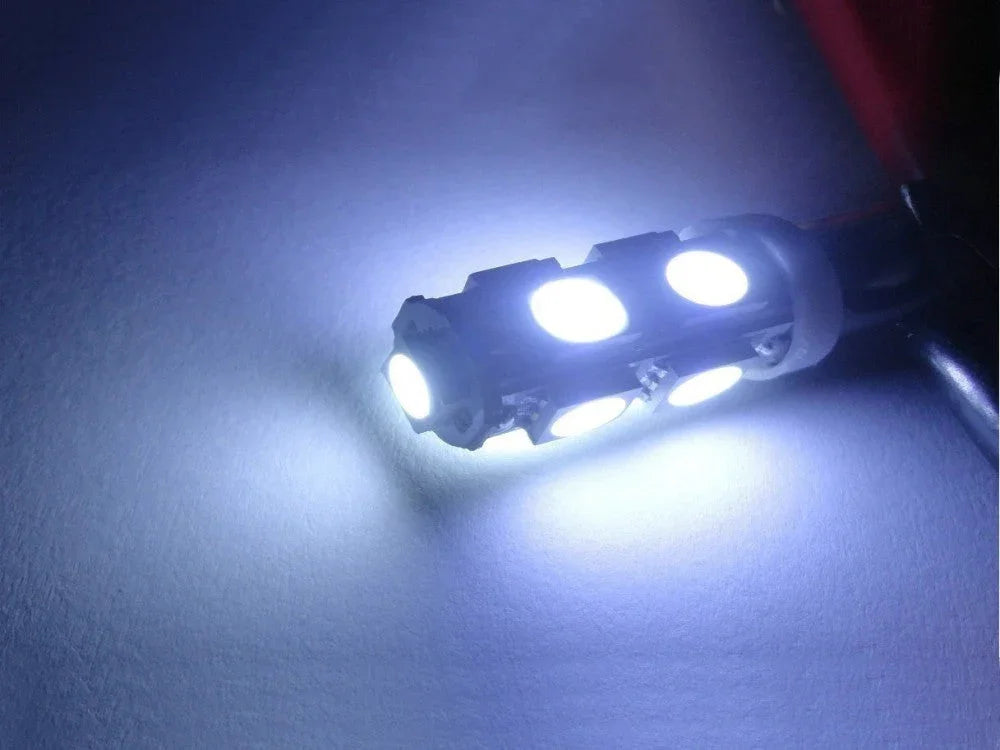 Close-up of a bright white LED bulb with multiple diodes emitting cool light on a white surface