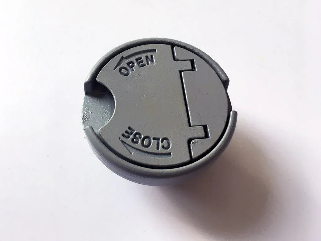 Gray round plastic lid with open and close arrows on white background