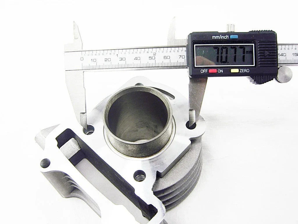 Metal engine cylinder part measured with a digital caliper showing 70.77 mm diameter