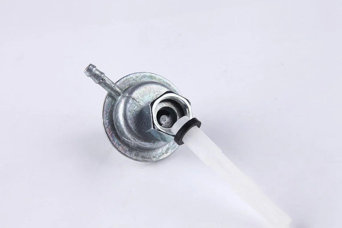 Metal fuel petcock valve with white plastic filter on a white background