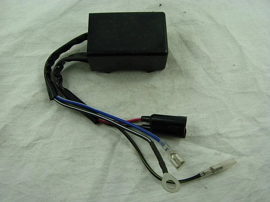 Black electronic control unit with multiple colored wires and connectors on white fabric background