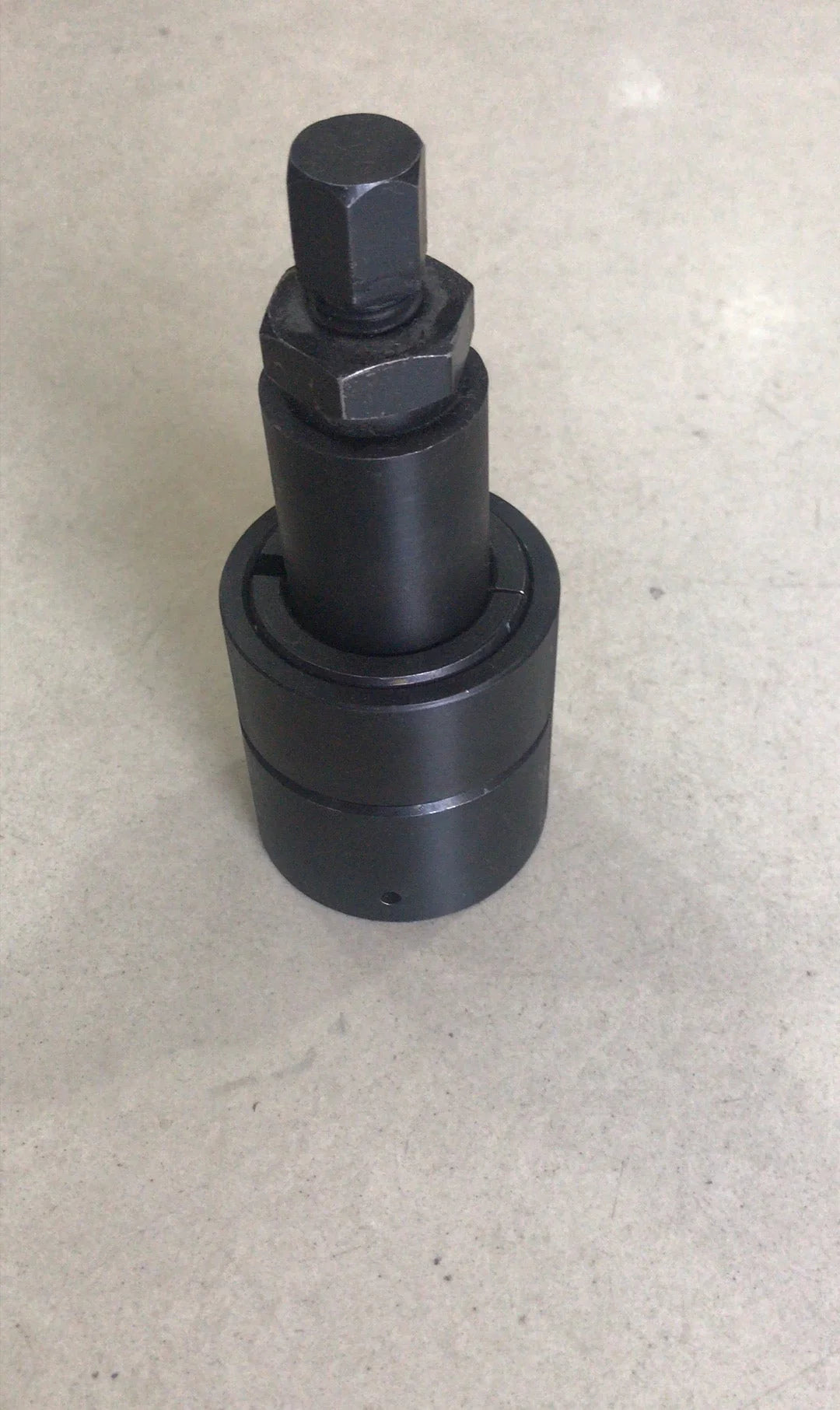 black metal mechanical tool part with hexagonal bolt on gray surface
