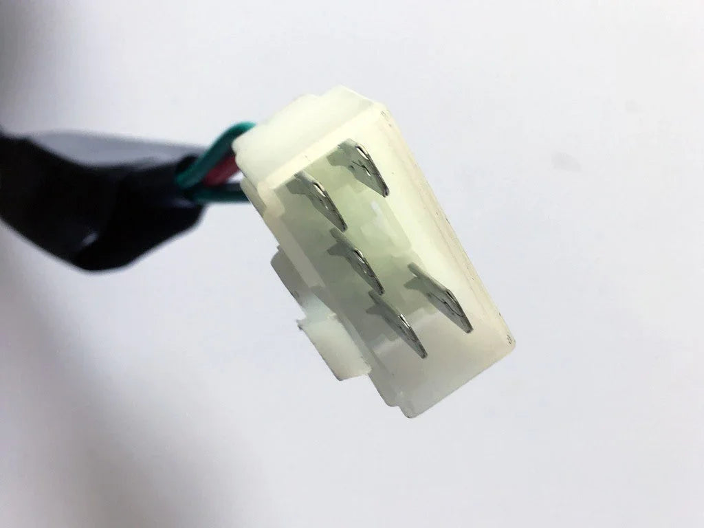 Close-up of white plastic electrical connector with metal pins and multicolored wires