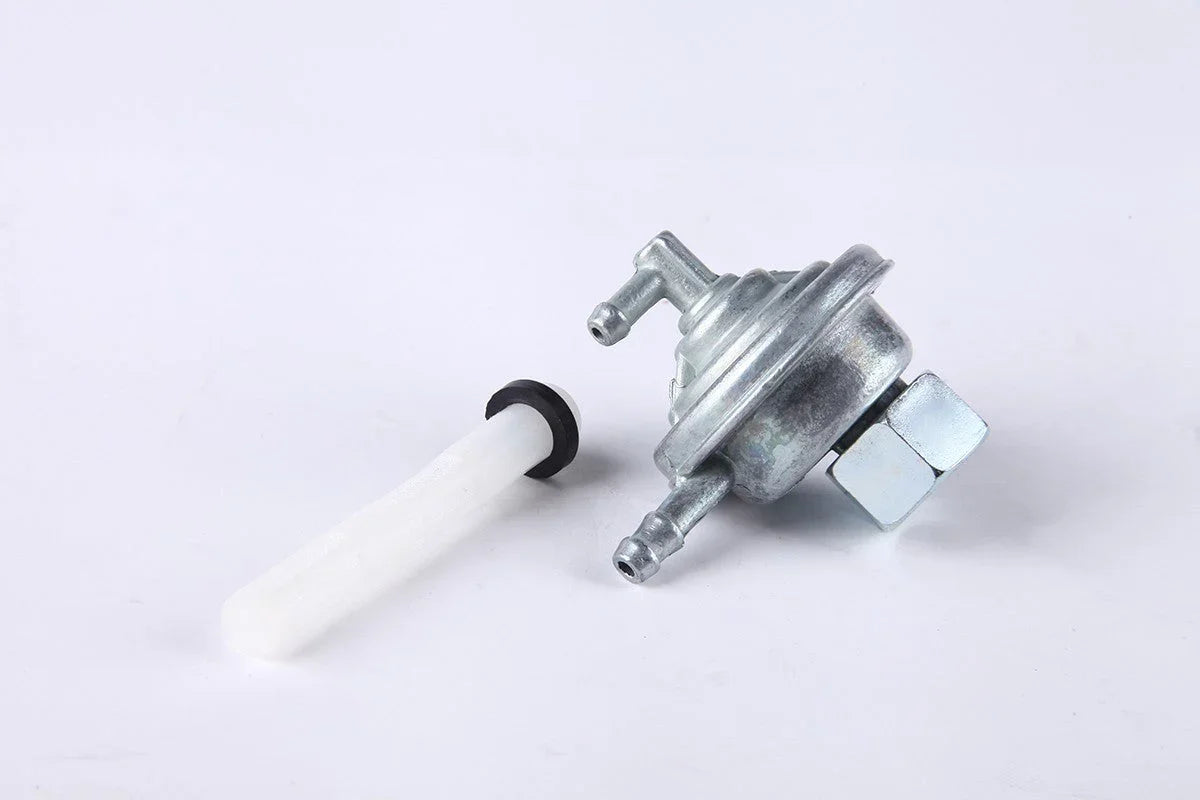 metal fuel petcock valve with a white fuel filter on white background for motorcycle