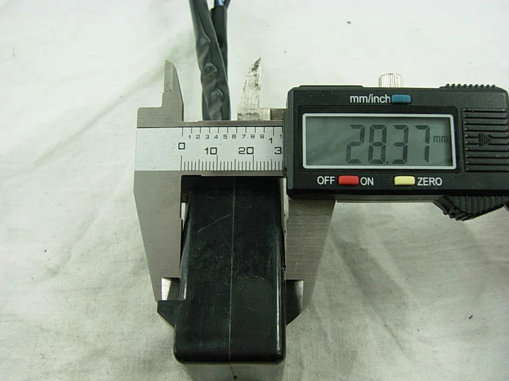 digital caliper measuring 28.37 mm width of a black rectangular electronic component