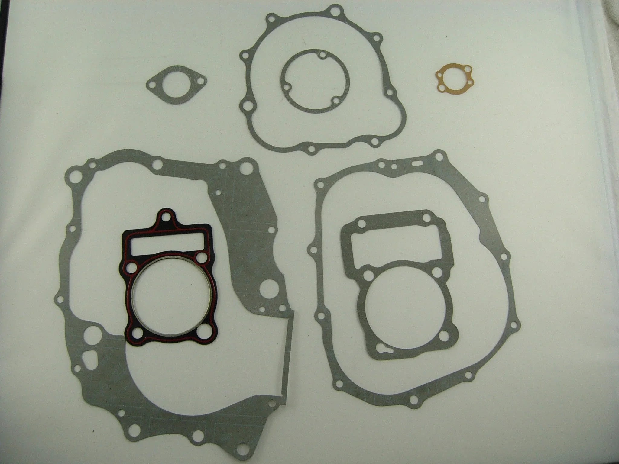 Set of various engine gaskets in different shapes and sizes on a white background