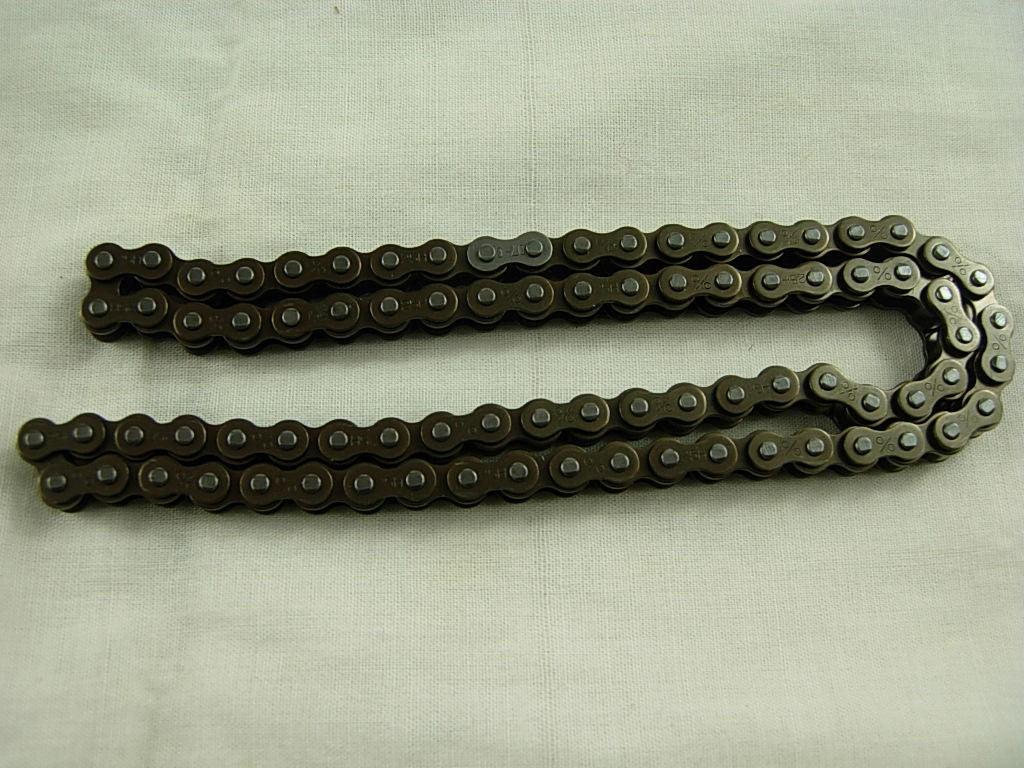 Close-up of a black metal bicycle chain laid out on a white fabric background