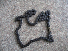420 136-link metal chain for dirt bike or pit bike laid on a granite surface