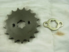 Metal sprocket gear and locking plate on white cloth background with rust stains