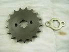 Metal sprocket gear and locking plate on white fabric background