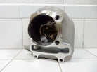 Aluminum motorcycle engine cylinder with visible piston pin inside, set on white tiled surface