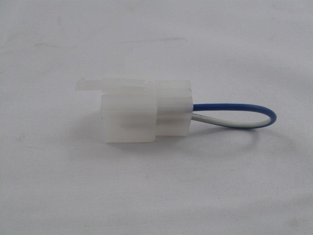 White plastic electrical connector with blue and white wire loop on white fabric background