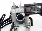 Digital caliper measuring 24.03 mm on a metal carburetor component with black cables
