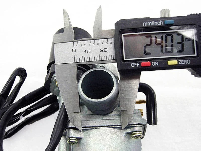 Digital caliper measuring 24.03 mm on a metal carburetor component with black cables