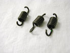 Set of three small black metal coil springs with hooks on white fabric background
